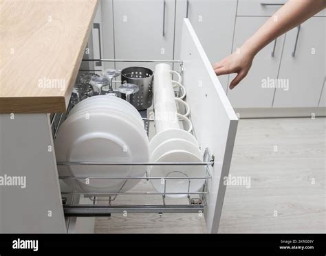 Pull-out shelf with dishes in a modular kitchen. Modern kitchen ...