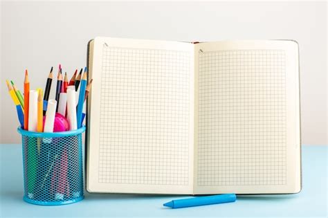 Offenes Heft mit Vorderansicht mit Filzstiften und Bleistiften auf ...