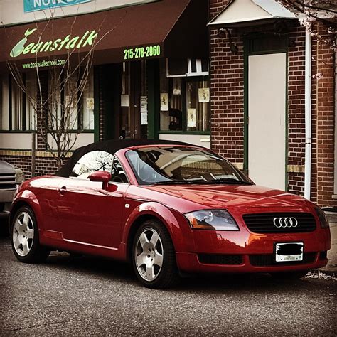a red convertible car parked in front of a restaurant