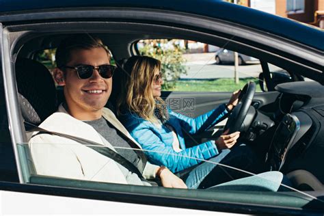 年轻女驾驶汽车的侧面与微笑的男朋友相高清图片下载-正版图片502919789-摄图网