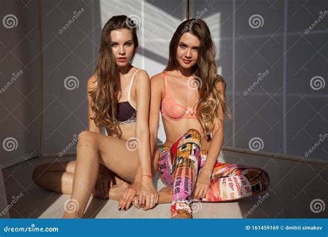 Two Beautiful Women in Lingerie Sit Side by Side on the Floor of the ...