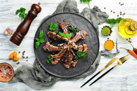 Gebratene Lammrippen mit Gewürzen und Knoblauch auf einem dunklen ...