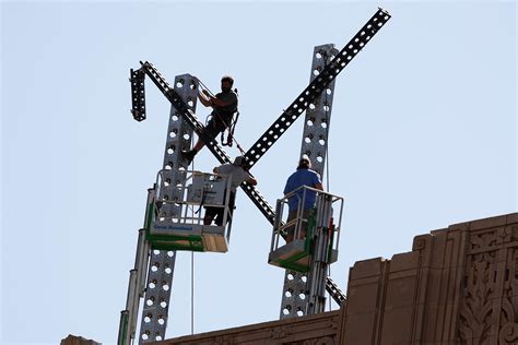 Workers begin dismantling a large X logo on the roof of X Headquarters in San Francisco ...