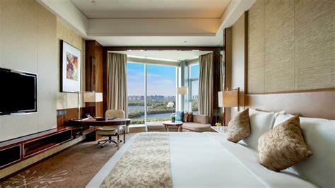 JW Marriott bed in hotel room with logo on an accent pillow