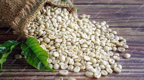 Premium Photo | Unroasted green coffee beans in brown sacks on wooden ...