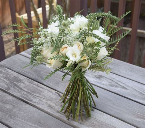 Holiday twist on a hand-tied bouquet with green and white flowers ...