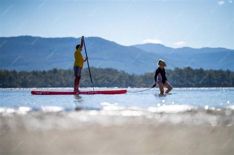Premium Photo | Paddle boarding on the water with mountains in the ...