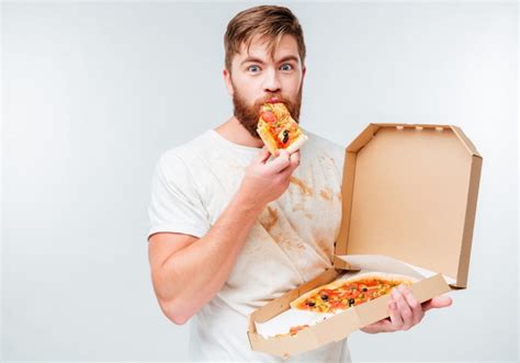 Happy hungry man eating pizza from a box - Tratamiento y Enfermedades