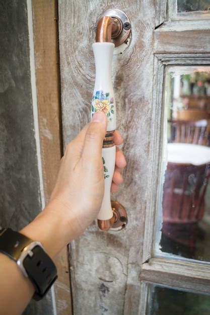 Female hand opening vintage cafe door | Premium Photo