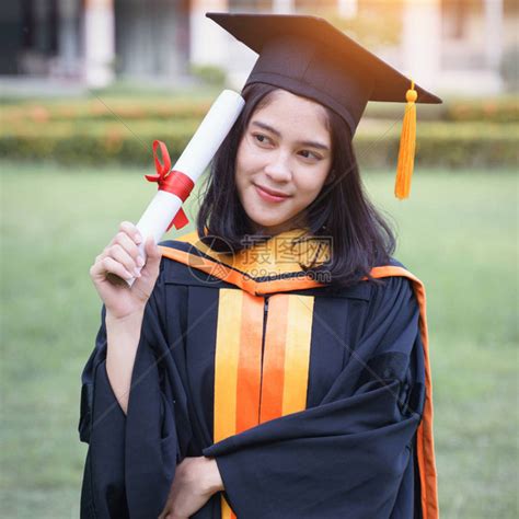 年轻的亚洲女子大学毕业生在毕业典礼上获得大学位证书后高清图片下载-正版图片503848285-摄图网