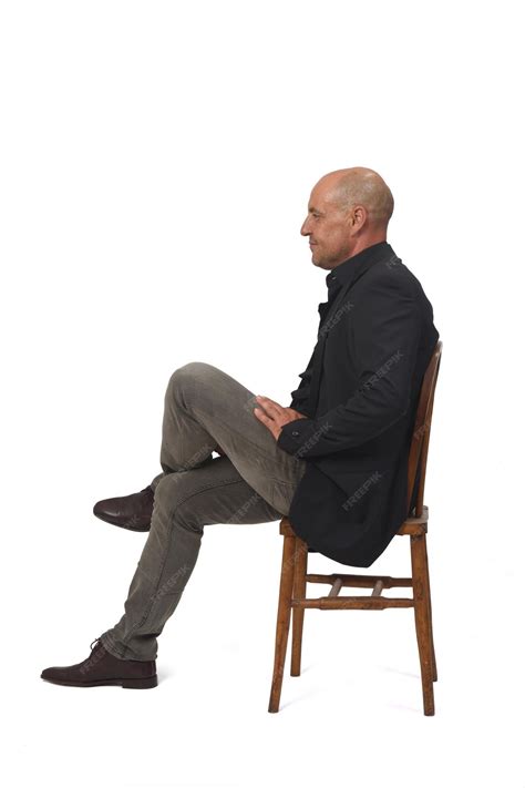 Premium Photo | Side view of a full portrait of a man sitting on chair ...