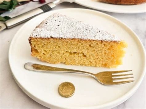 side view of Vaselopita - Greek New Years Cake dusted with powdered sugar with a slice cut out of it