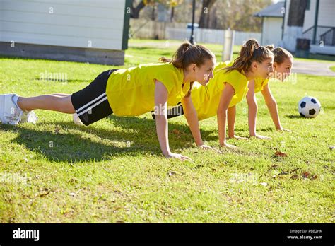 Friend girls teens push up push-ups workout ABS in a park turf grass ...