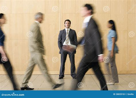 Confident Businessman With Team Walking Past Him Royalty Free Stock ...