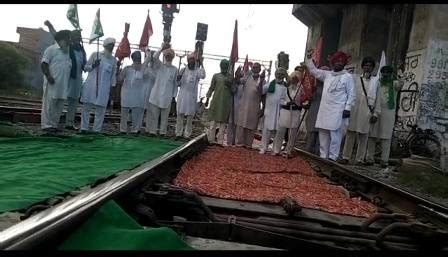 Farmers standing on rail track jam-line, shouting slogans against the ...