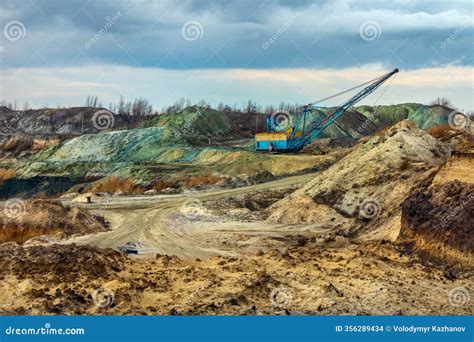 A Dragline Excavator Walking in a Mining Quarry. Piles of Soil of ...