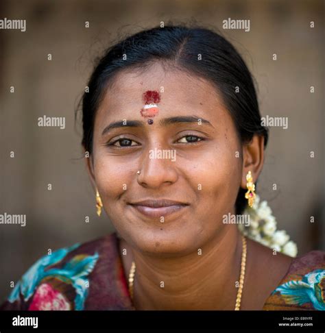 Woman with bindi on her forehead wearing gold ear rings, portrait ...