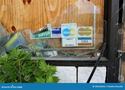 Broken Boarded Up Window with Credit Card Insignia Stickers Editorial ...