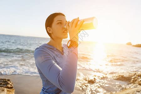 女人海滩上喝水轻女子海滩上锻炼后喝水高清图片下载-正版图片300474011-摄图网