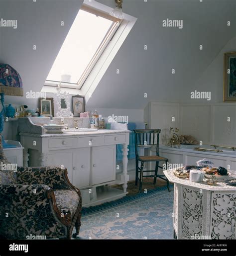 Velux window above basin in painted white washstand in attic bathroom ...
