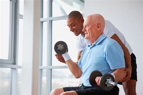 Healthy senior man assisted by fitness trainer in gym - Oakleaf Brain ...