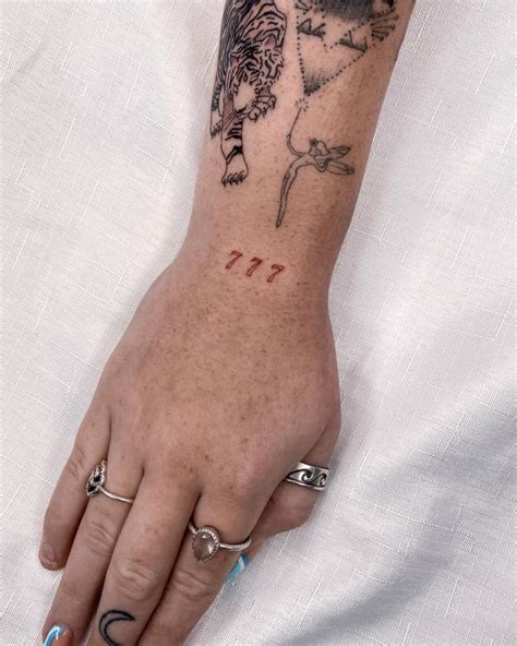 777 spine tattoo,This design symbolizes luck and fortune