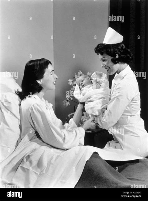 1950s NURSE HANDING NEWBORN INFANT TO MOTHER IN HOSPITAL BED Stock ...