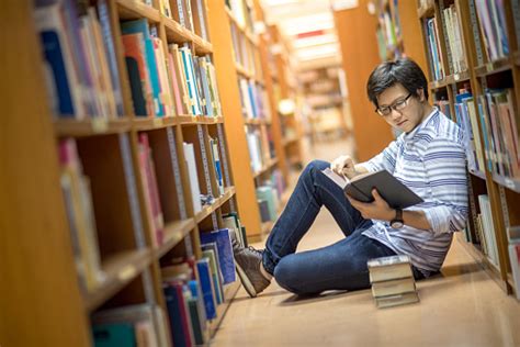Young Asian Man University Student Reading Book In Library Stock Photo ...