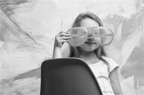 Happy baby girl wearing glasses sitting on chair | Premium Photo