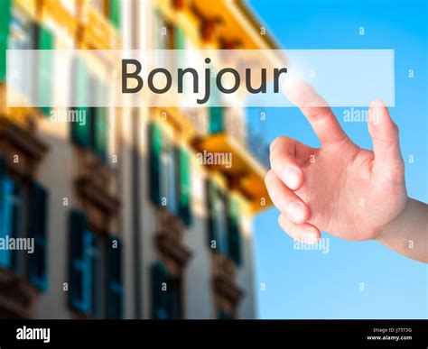 Bonjour (Good Morning in French) - Hand pressing a button on blurred ...