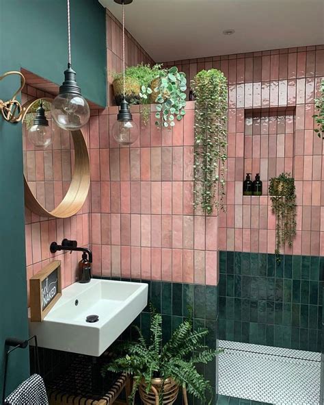 a bathroom with green and pink tiles on the walls, potted plants ...