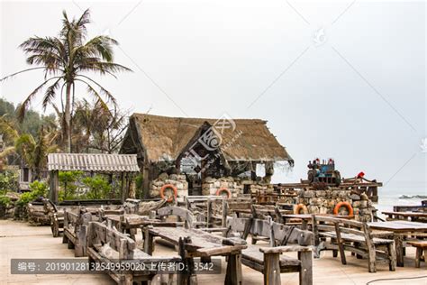 专注于海滩酒吧日光躺椅旁边木桌上的杯子海滩是高清图片下载-正版图片506644191-摄图网