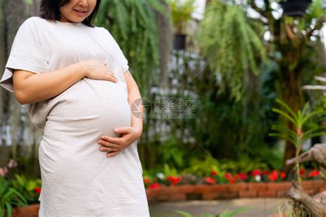 孕妇在照顾孩子的同时在家感到快乐年轻的准妈抱着婴儿在怀孕的肚子里产前护理和高清图片下载-正版图片506126518-摄图网