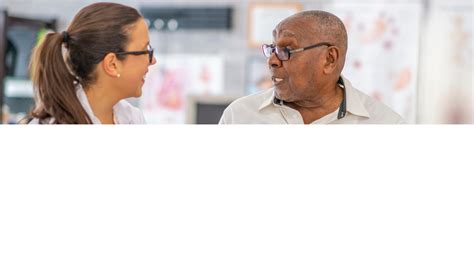 Doctor talking with an older patient during a medical checkup.