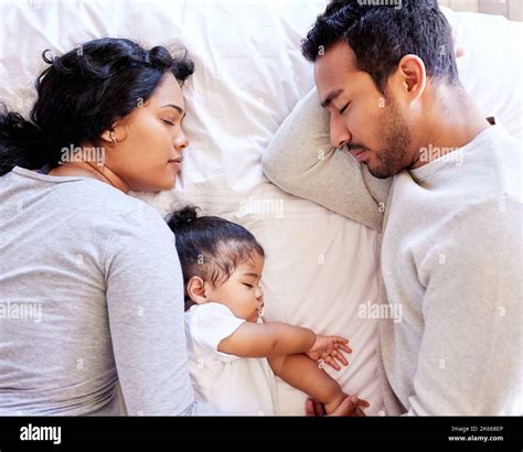 Young family sleeping together from above. Two parents sleeping with ...