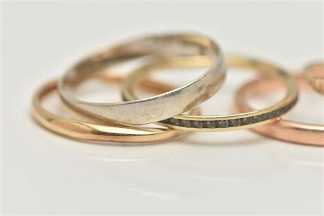 FIVE RINGS, to include three band rings, two with 9ct hallmarks, a 9ct ...