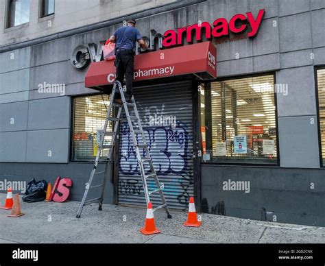 A worker removes the signage from a closed store in the CVS Health drugstore chain in Chelsea in ...