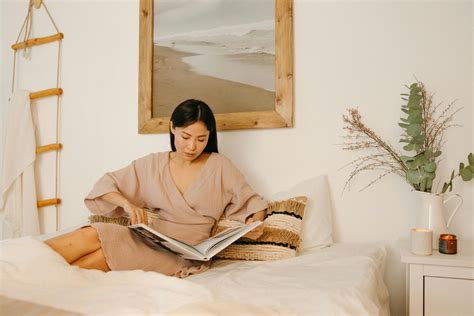 Woman reading in The Ritz-Carlton bed at a hotel