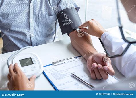 Doctor Using Stethoscope Checking Measuring Arterial Blood Pressure on ...