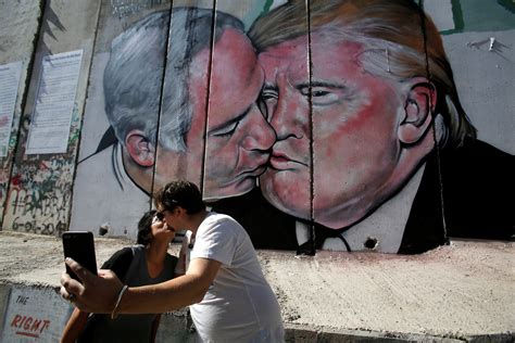 Trump and Netanyahu share a kiss on West Bank wall mural | Reuters