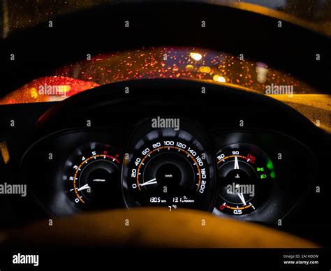 Glowing car dashboard at night against the background of raindrops on ...