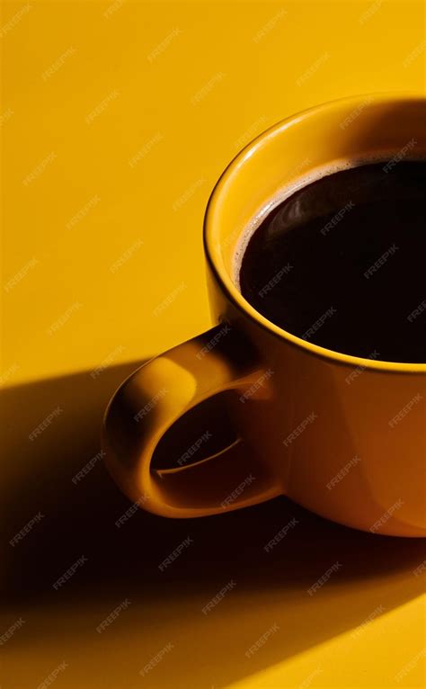 Premium Photo | Cup of freshly brewed roasted coffee beans on yellow ...