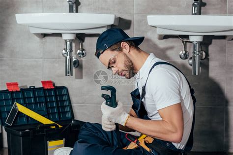 年轻的专业水管工在浴室里固定水槽高清图片下载-正版图片505068382-摄图网