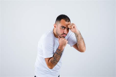 Young man standing in boxer pose in white t-shirt and looking powerful ...