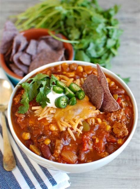 A bowl of Laura's quick slow cooker turkey chili, topped with shredded cheese, sliced green onions,