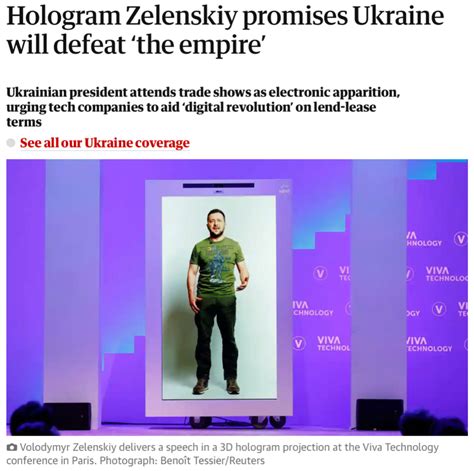 Zelensky wearing a green shirt speaks in a dimly-lit room. An out-of-focus Christmas tree is in the