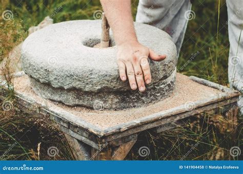 El Molino De Mano Antiguo De La Piedra Del Quern Con El Grano El Hombre ...