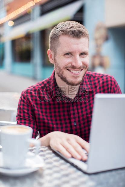 二十多岁自由职业者喝外门咖啡厅在笔记本电脑上工作的年轻人肖像高清图片下载-正版图片307782734-摄图网