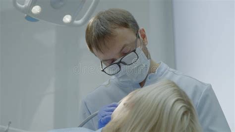 Dentist carrying out dental procedure on male patient, close-up