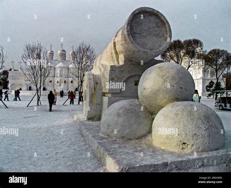 A packed snow sculpture of an old style cannon with 3 huge cannon balls ...